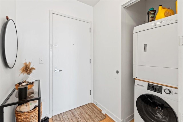 washroom featuring stacked washer / dryer