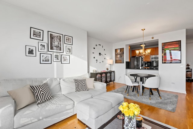 living room with an inviting chandelier and light hardwood / wood-style flooring