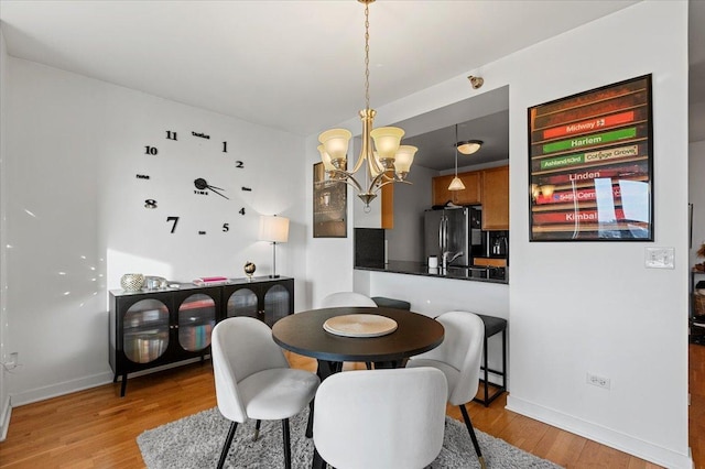 dining area with a chandelier and light wood-type flooring