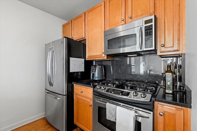 kitchen featuring tasteful backsplash, stainless steel appliances, and hardwood / wood-style floors