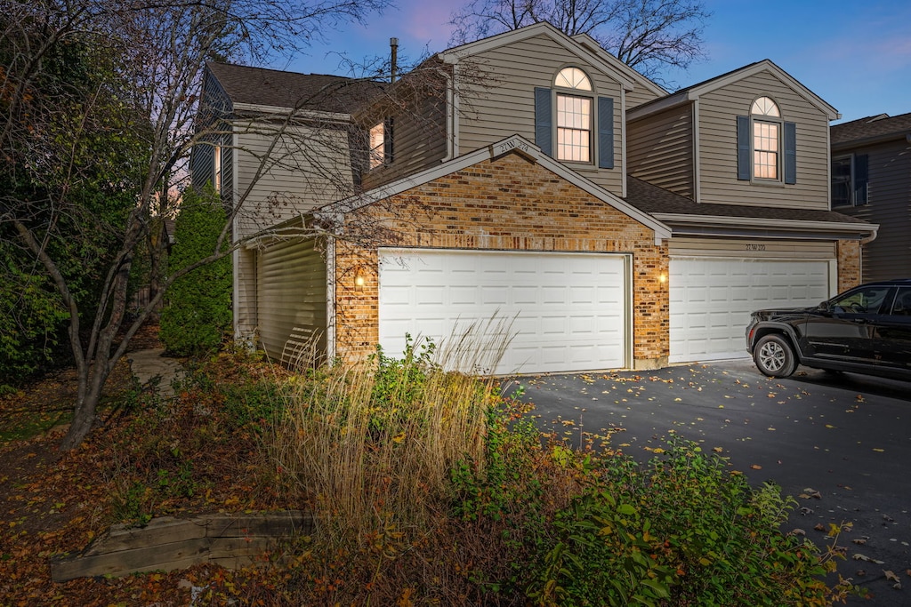 property exterior at dusk featuring a garage