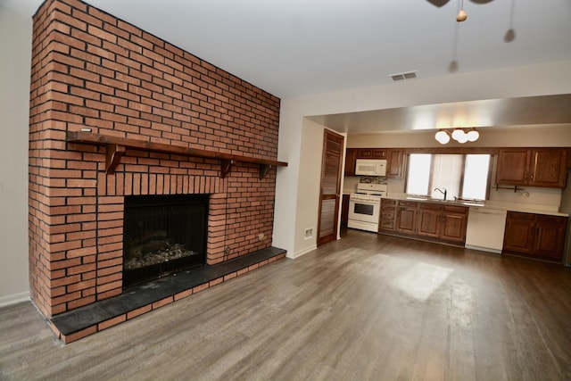 unfurnished living room featuring a fireplace, dark hardwood / wood-style floors, and sink