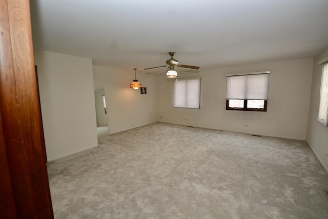 empty room featuring ceiling fan and light carpet