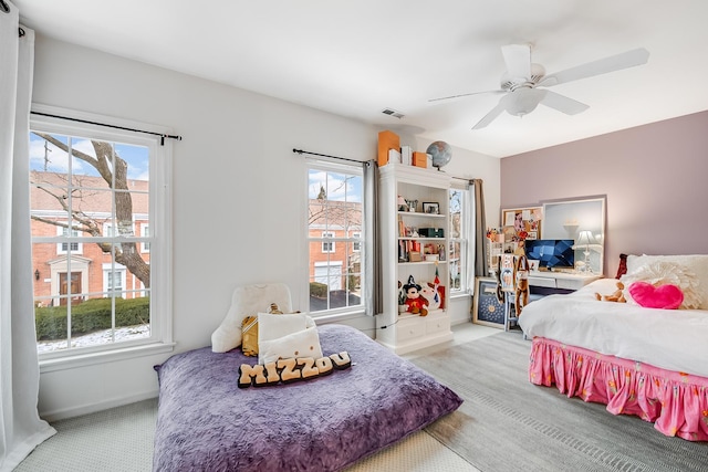 carpeted bedroom with ceiling fan and multiple windows