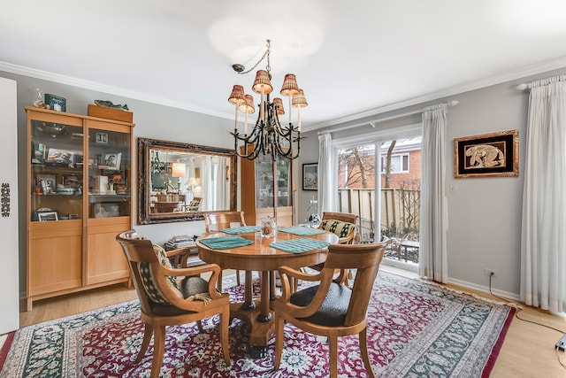 dining space with a chandelier, ornamental molding, and light hardwood / wood-style flooring