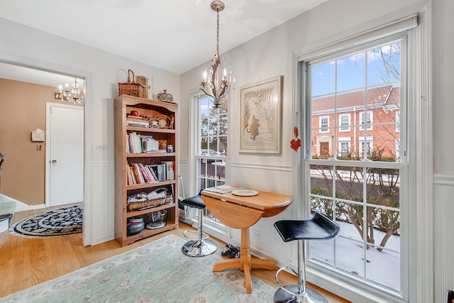 office space with a wealth of natural light, hardwood / wood-style floors, and a notable chandelier