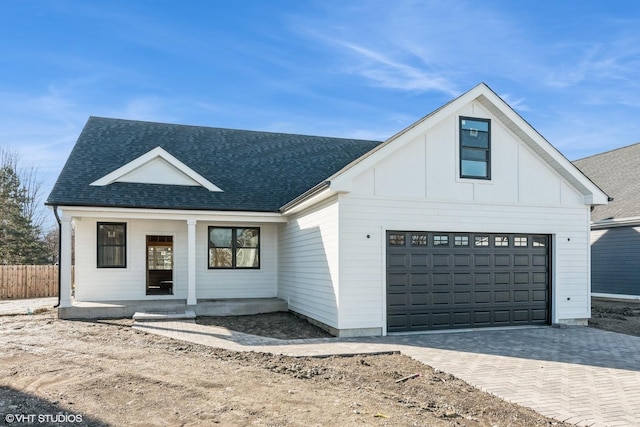 modern inspired farmhouse with a garage and covered porch