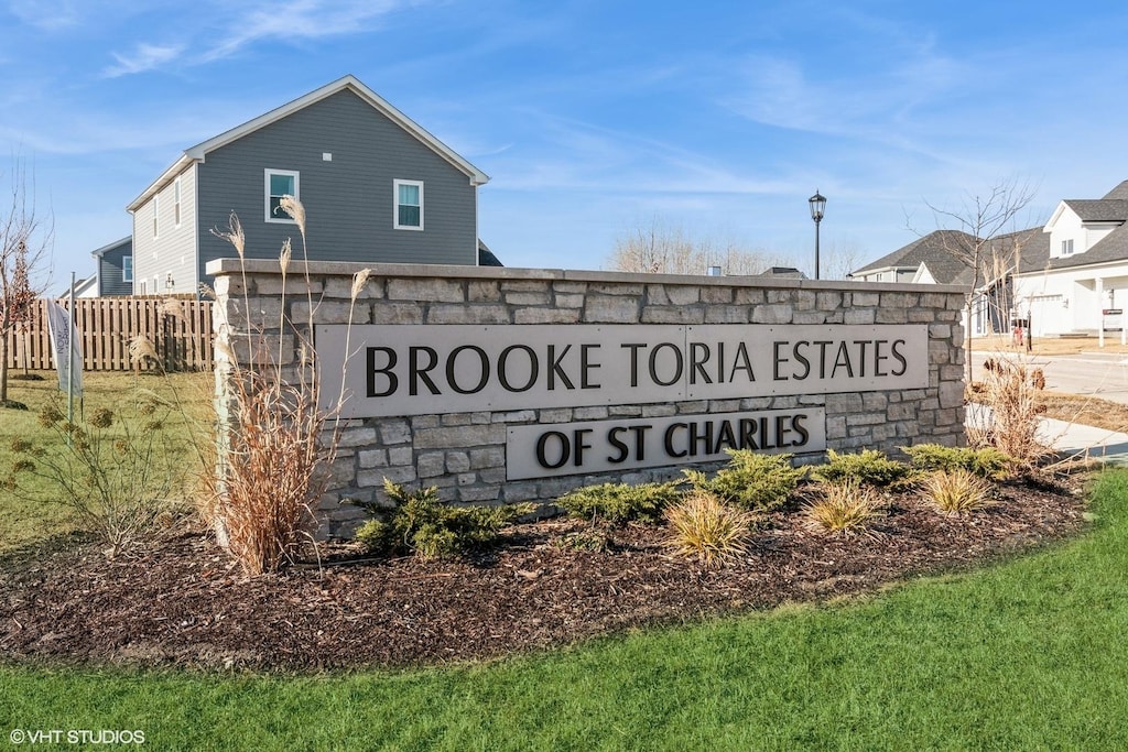 community / neighborhood sign with a yard