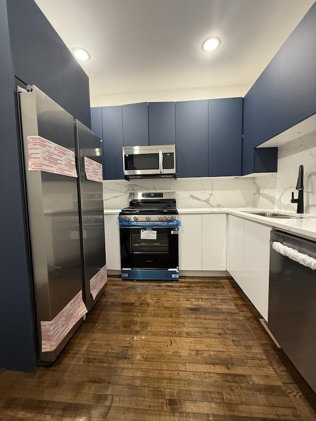 kitchen with white cabinets, sink, blue cabinets, and appliances with stainless steel finishes