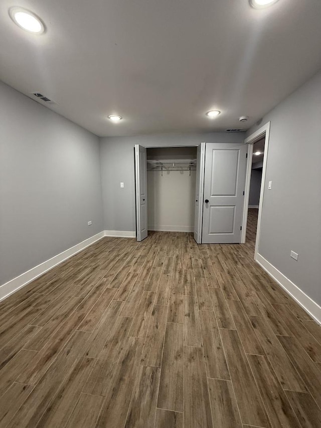 unfurnished bedroom with a closet and hardwood / wood-style flooring