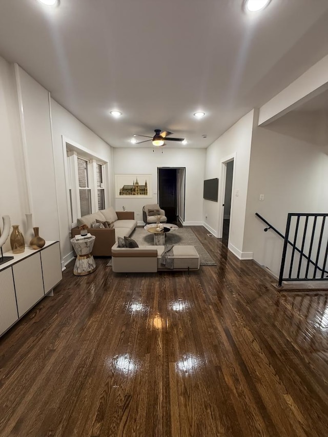 living room featuring ceiling fan and dark hardwood / wood-style flooring