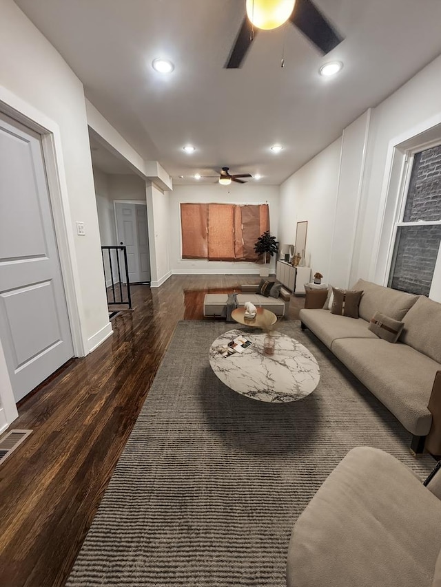 living room featuring ceiling fan and dark hardwood / wood-style floors