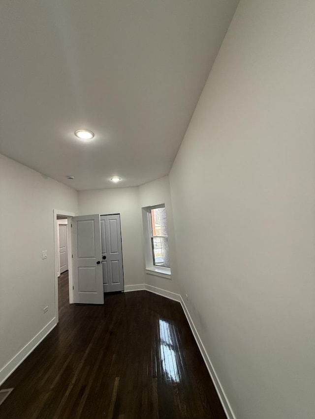 unfurnished bedroom with dark hardwood / wood-style floors and a closet