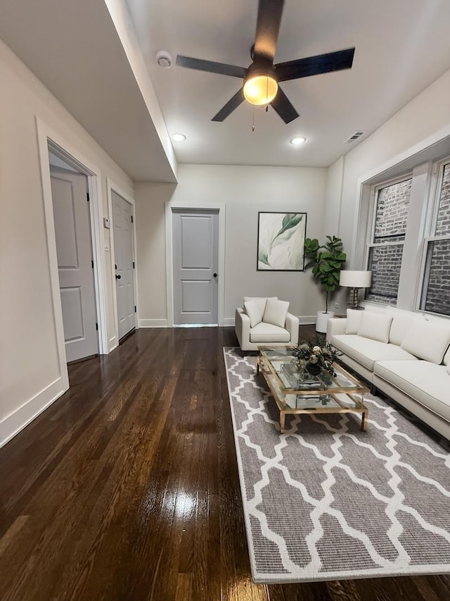 living room featuring ceiling fan and dark hardwood / wood-style floors