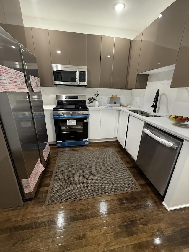 kitchen with sink, dark hardwood / wood-style floors, gray cabinets, appliances with stainless steel finishes, and white cabinetry