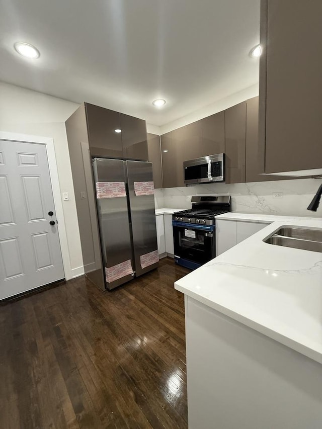 kitchen featuring stainless steel appliances, gray cabinets, dark hardwood / wood-style floors, and sink