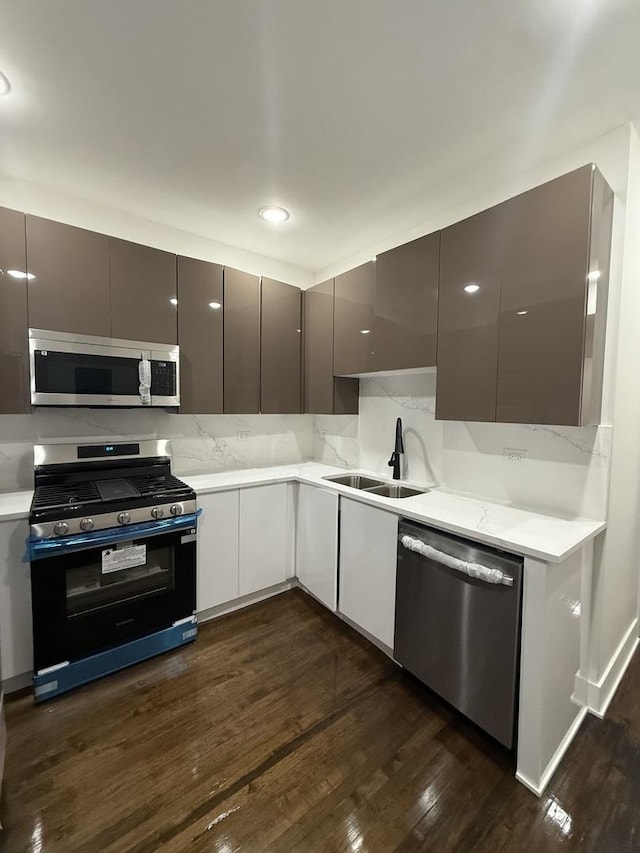 kitchen featuring backsplash, sink, dark wood-type flooring, and appliances with stainless steel finishes