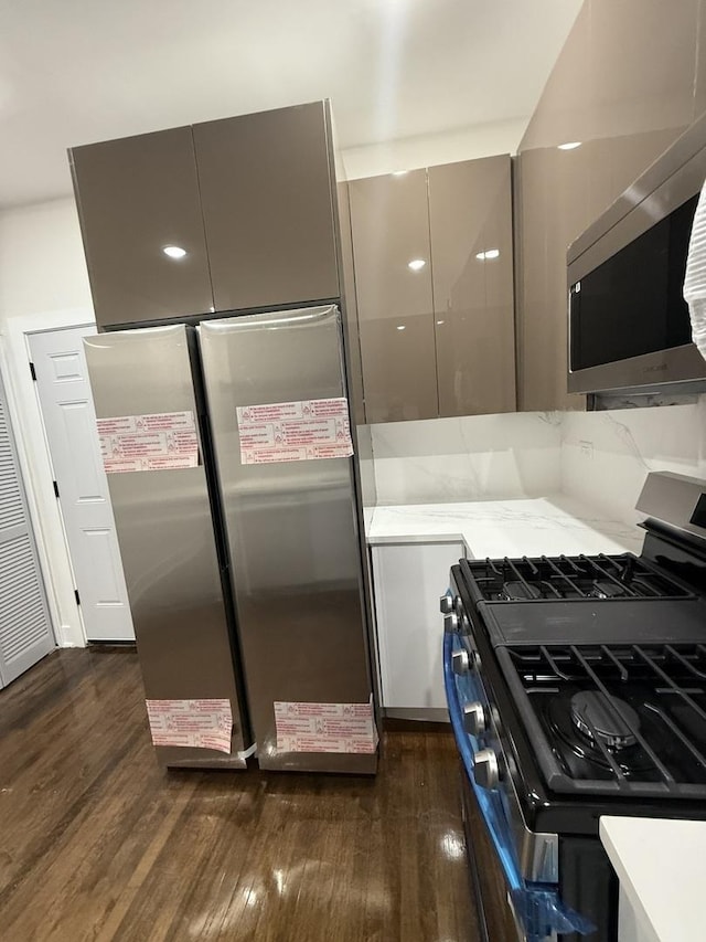 kitchen with stainless steel appliances, gray cabinets, and dark hardwood / wood-style floors