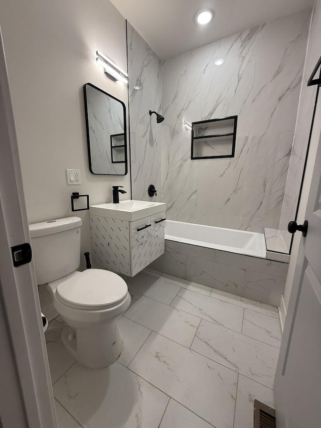 full bathroom featuring vanity, toilet, and tiled shower / bath