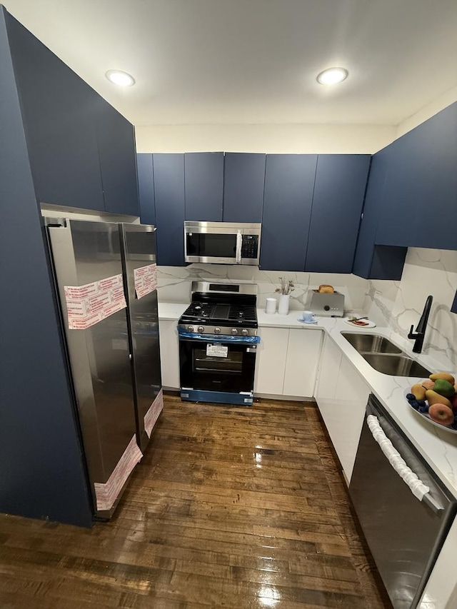 kitchen featuring blue cabinetry, sink, white cabinets, and stainless steel appliances