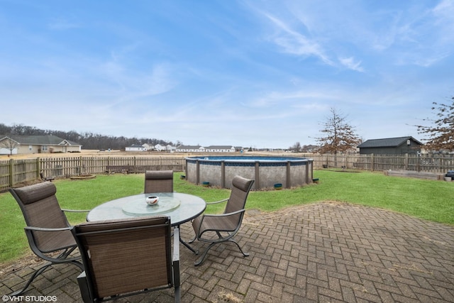 view of patio / terrace featuring outdoor dining space, a fenced backyard, and a fenced in pool