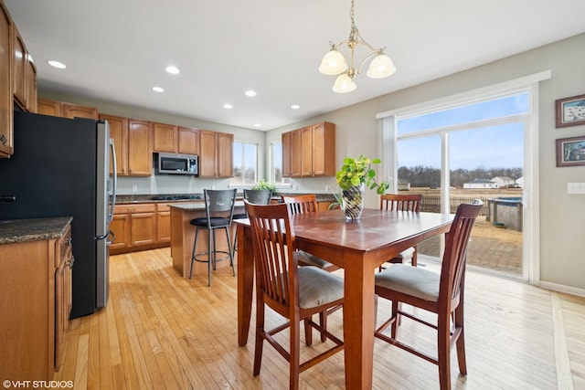 dining room featuring an inviting chandelier, light wood-style flooring, baseboards, and recessed lighting