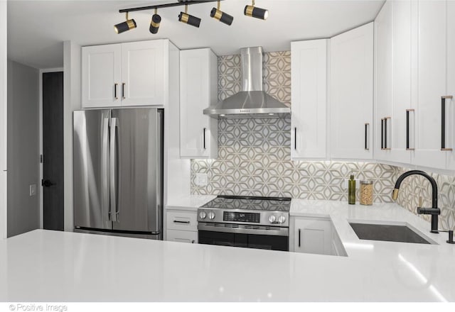 kitchen with backsplash, white cabinets, sink, wall chimney exhaust hood, and stainless steel appliances