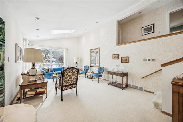 living area featuring light colored carpet and lofted ceiling with skylight