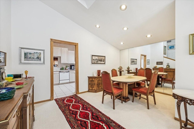 dining area featuring lofted ceiling and light carpet