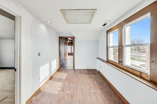 hall featuring hardwood / wood-style flooring and lofted ceiling