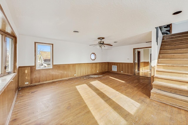 unfurnished room with hardwood / wood-style floors, a textured ceiling, and ceiling fan