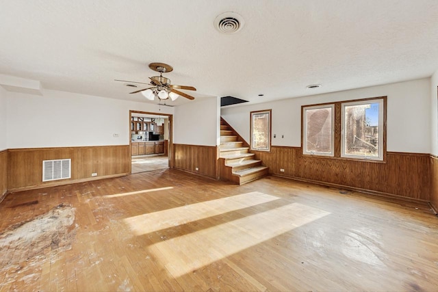 unfurnished living room featuring ceiling fan and light wood-type flooring