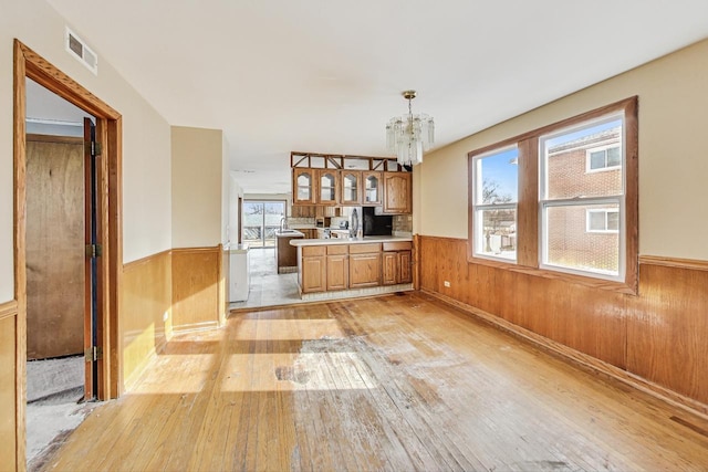 kitchen featuring light hardwood / wood-style floors, plenty of natural light, pendant lighting, and a notable chandelier