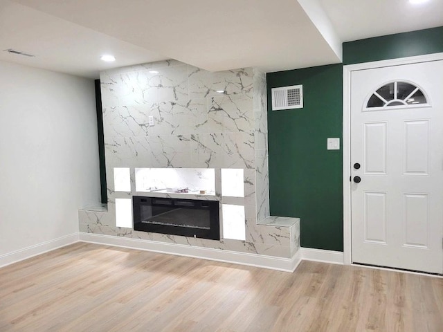 entryway featuring a premium fireplace and light hardwood / wood-style floors