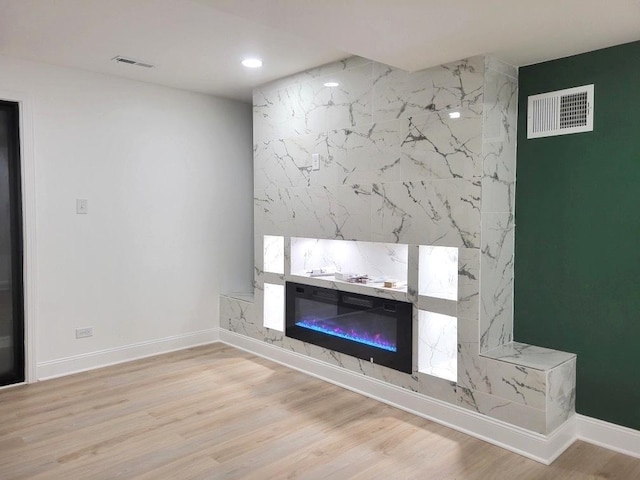 unfurnished living room with a premium fireplace and light wood-type flooring