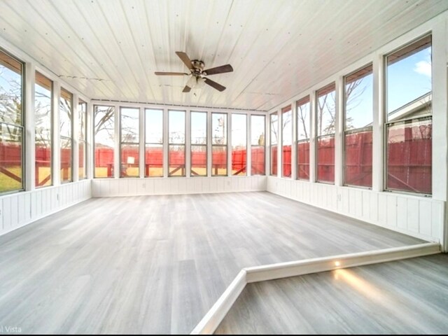 unfurnished sunroom featuring ceiling fan and wooden ceiling