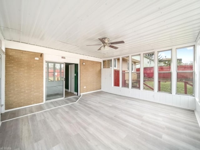 unfurnished sunroom with ceiling fan