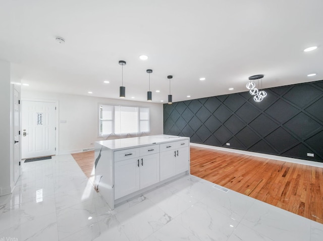 kitchen featuring white cabinetry, a kitchen island, and pendant lighting