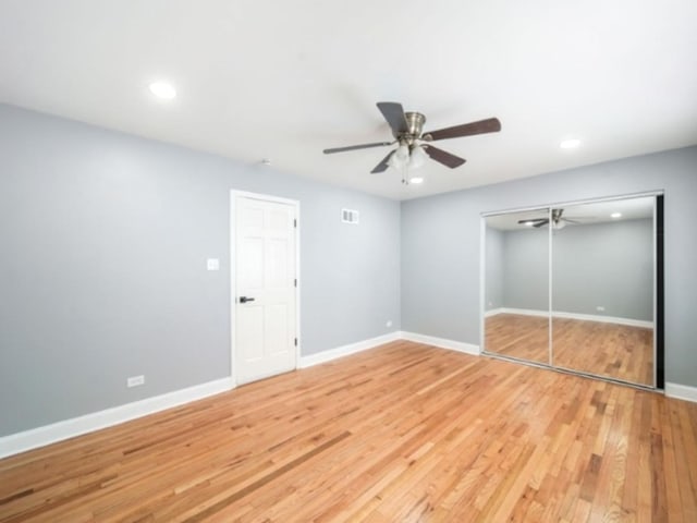 unfurnished bedroom with hardwood / wood-style floors, a closet, and ceiling fan