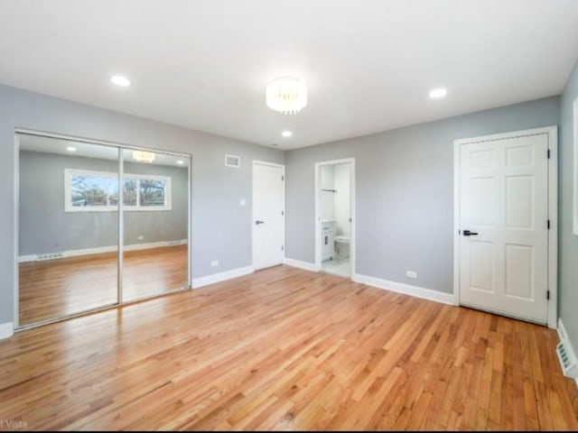 unfurnished bedroom featuring connected bathroom and light hardwood / wood-style flooring