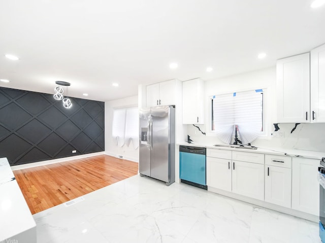 kitchen with white cabinetry, sink, and stainless steel appliances