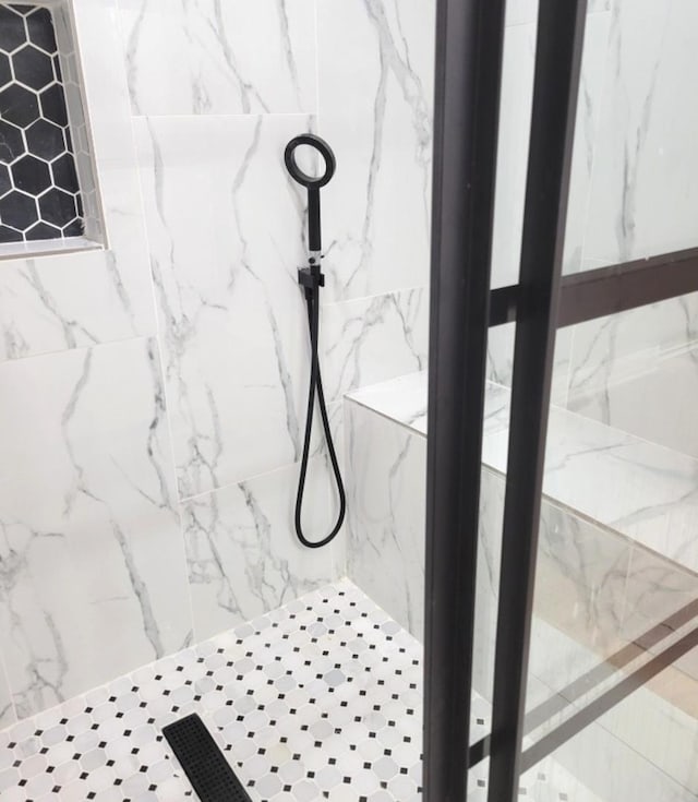 interior details featuring tiled shower