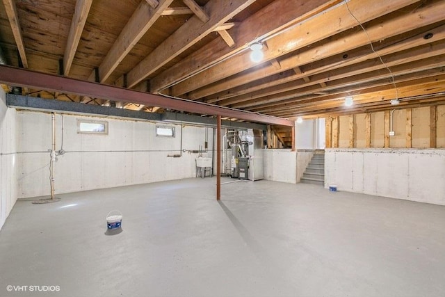 basement featuring heating unit and sink