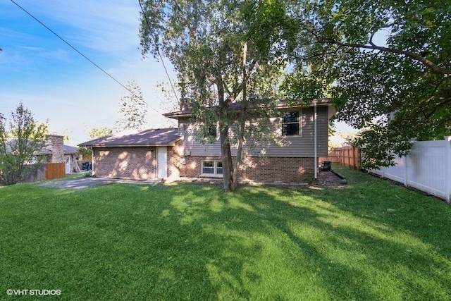 rear view of property featuring a lawn