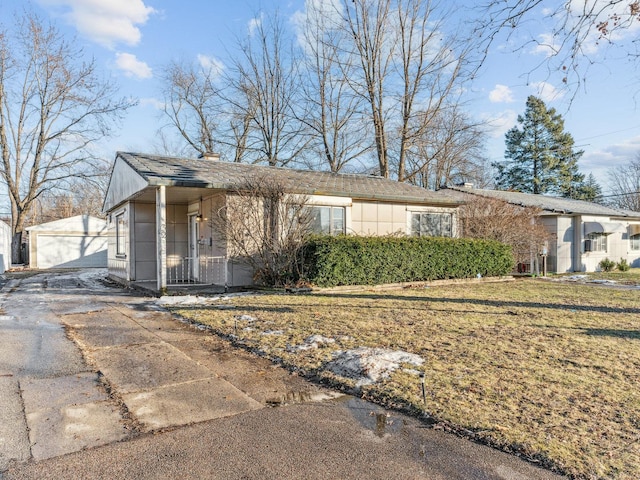 single story home with a garage, an outdoor structure, and a front yard