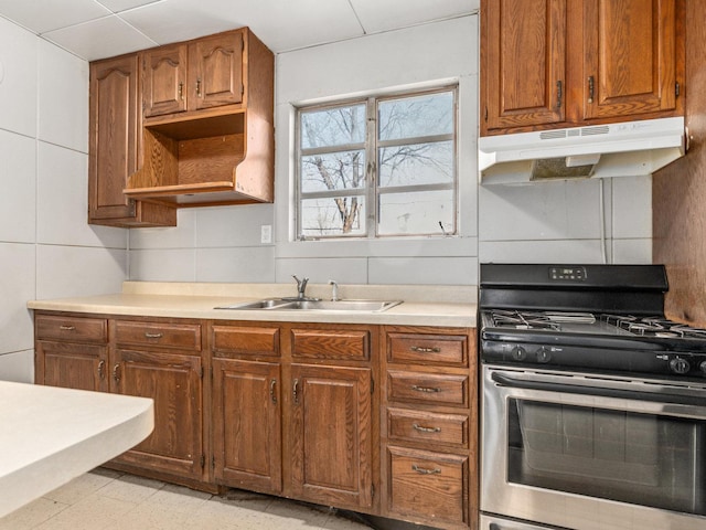 kitchen with tile walls, sink, and stainless steel range with gas cooktop