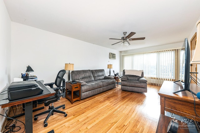 living room featuring ceiling fan, a wall mounted AC, and wood-type flooring