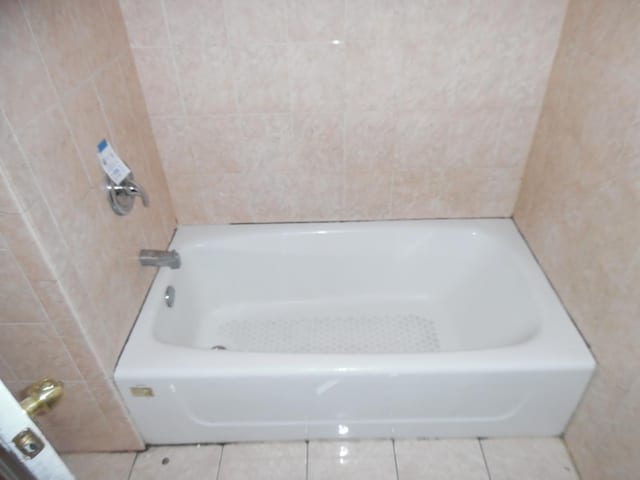 bathroom featuring tile patterned flooring and a bathtub