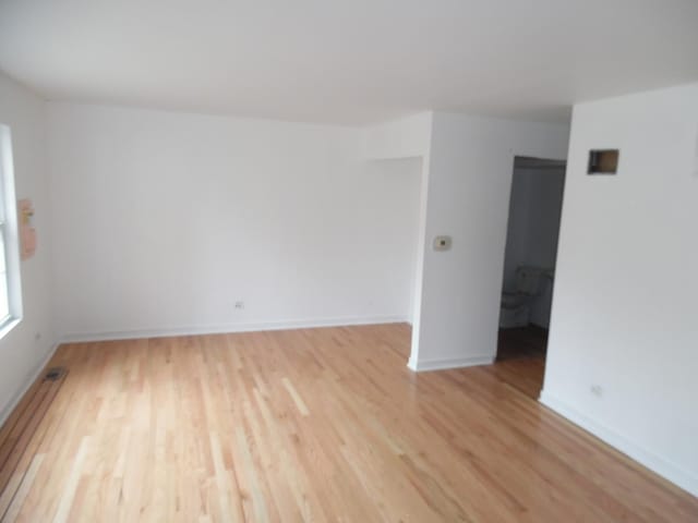 spare room with light wood-type flooring and baseboard heating