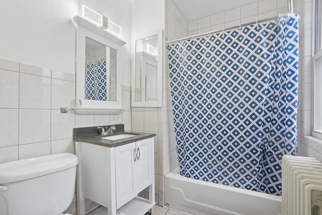 full bathroom featuring vanity, toilet, shower / bath combo with shower curtain, tile walls, and radiator heating unit